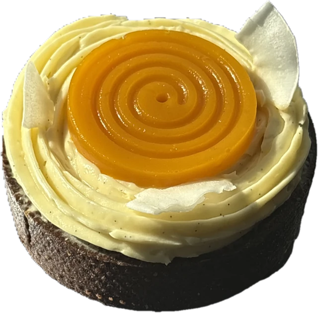 Tartă rotundă de cacao cu cremă de cocos, disc spiralat de jeleu de mango și fructul pasiunii, fulgi de ciocolată albă